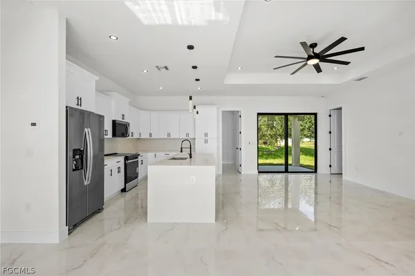 a view of a kitchen with refrigerator and windows