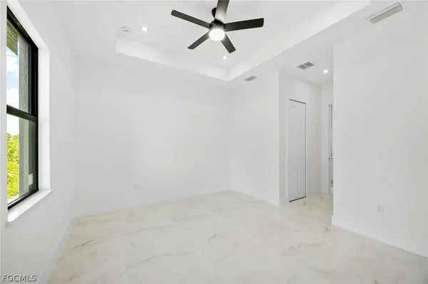 an empty room with windows and fan