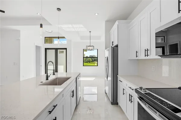 a kitchen with stainless steel appliances granite countertop a sink and a stove top oven