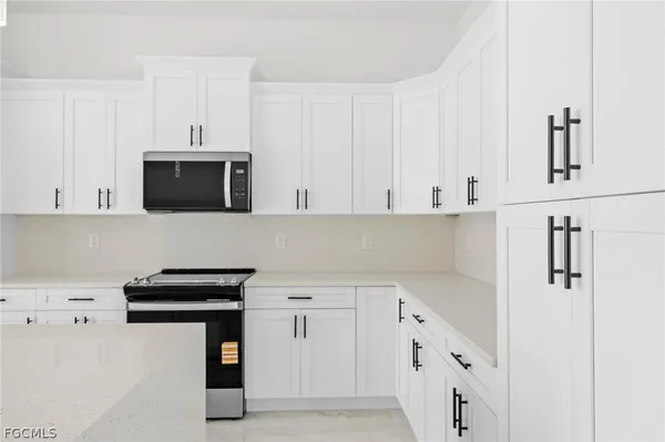 a kitchen with stainless steel appliances a stove microwave and cabinets