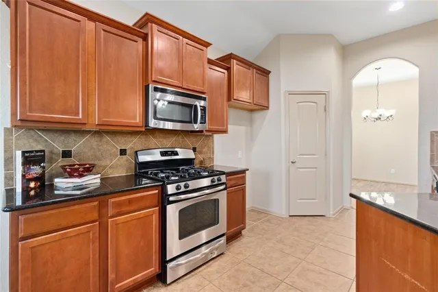 a kitchen with stainless steel appliances granite countertop a stove a microwave and a refrigerator
