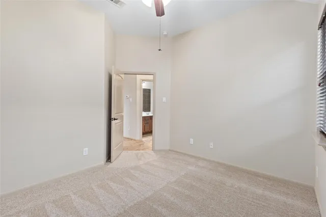 an empty room with ceiling fan and entrance