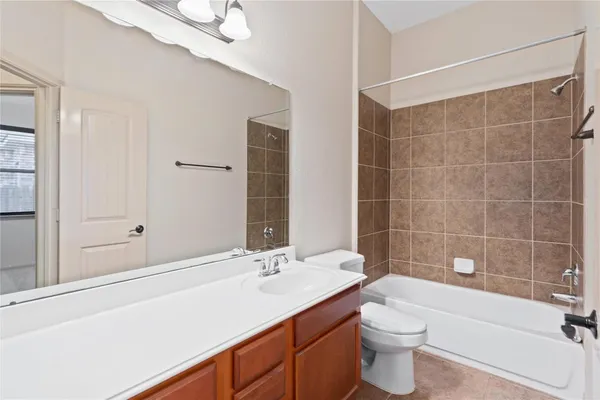 a bathroom with a sink a toilet a mirror and bathtub