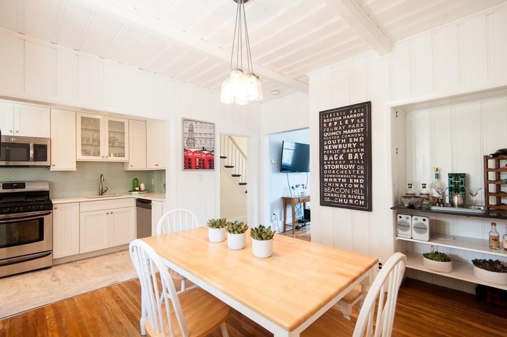 2 Dixfield Street, Unit SF Boston, MA 02127 - Photo 1 of 1 a kitchen with a stove a sink dishwasher a dining table and chairs with wooden floor