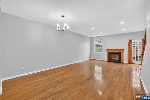 an empty room with wooden floor and fireplace