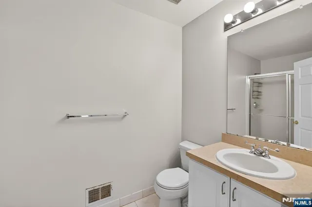 a bathroom with a sink vanity granite and toilet