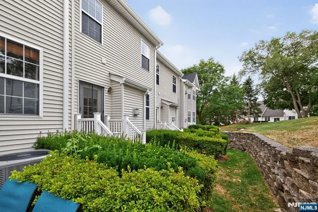 a view of a house with a yard and potted plants