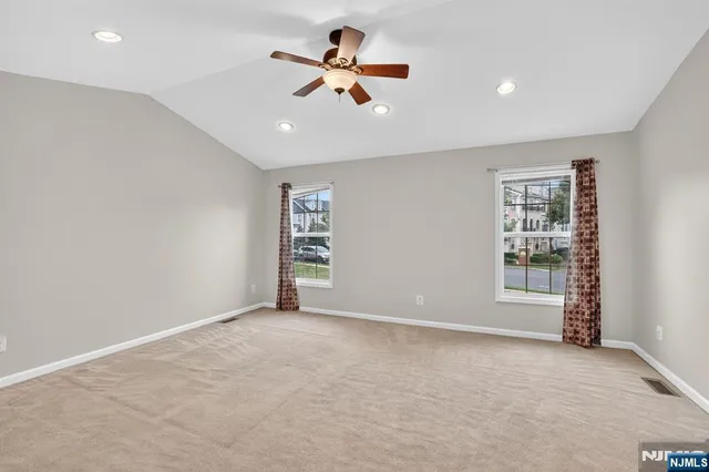 an empty room with ceiling fan and window
