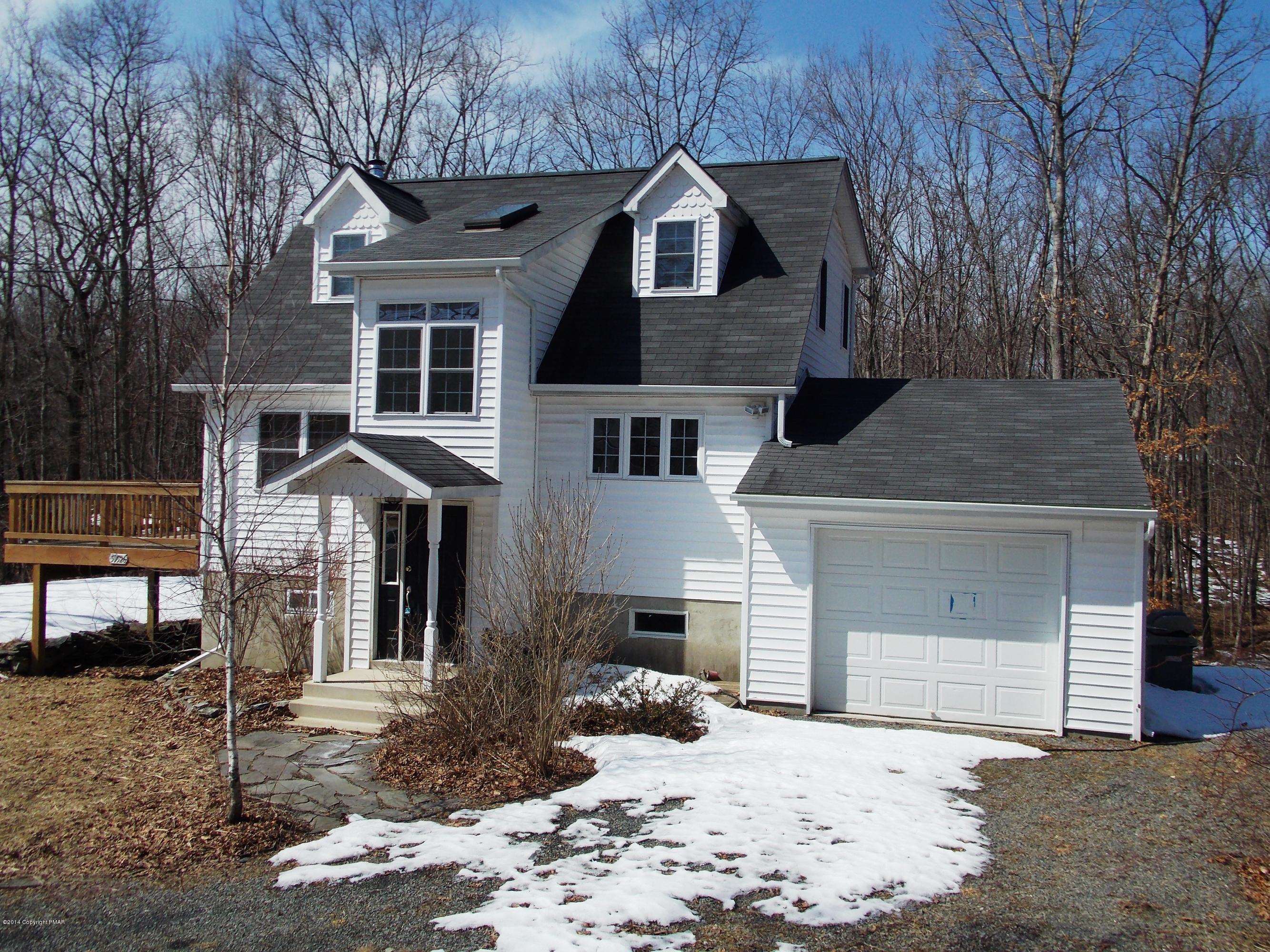 a front view of a house with a yard covered in snow