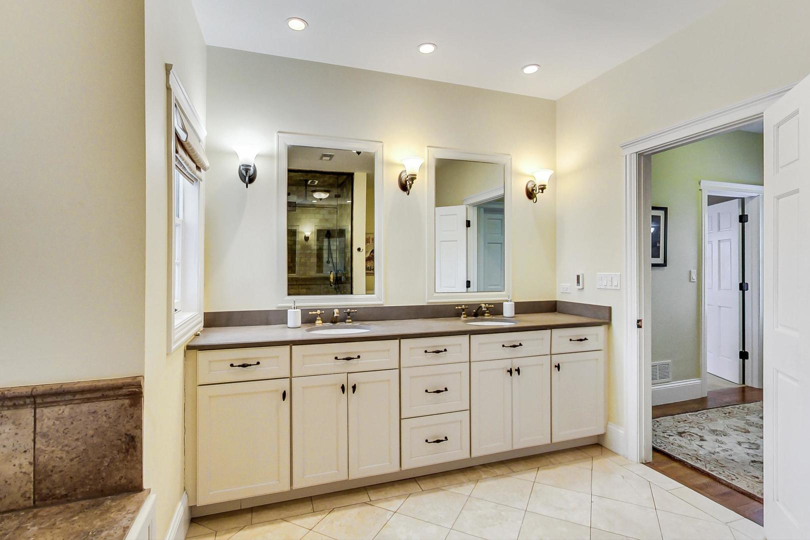 615 Windsor Road Glenview, IL 60025 - Photo 25 of 51 a spacious bathroom with a granite countertop sink a mirror and a shower