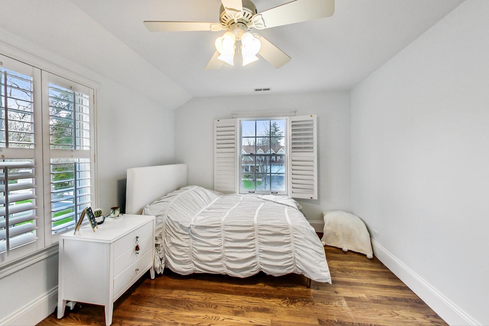 615 Windsor Road Glenview, IL 60025 - Photo 30 of 51 a bedroom with a bed and a chandelier