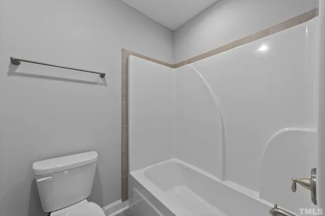 a white toilet sitting next to a bath tub