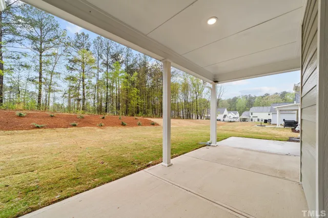 a view of swimming pool with lawn chairs and large trees