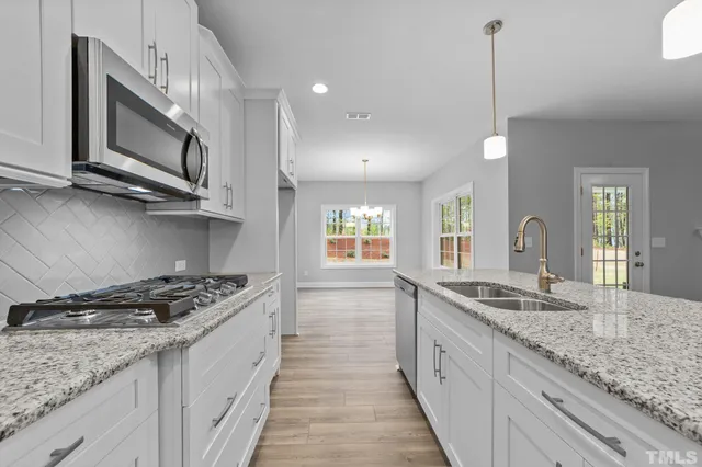 a kitchen with stainless steel appliances granite countertop a sink and stove
