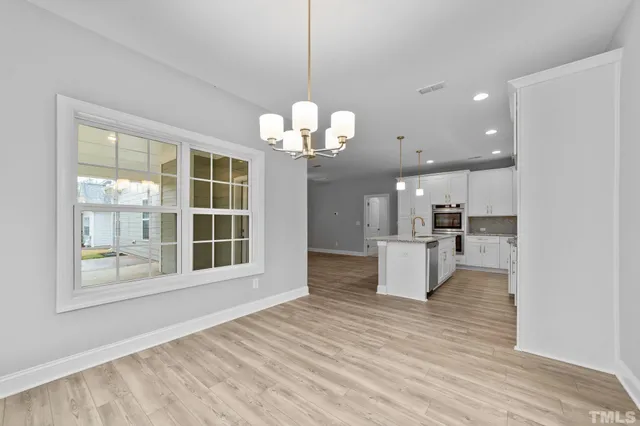a view of a big room with wooden floor and windows