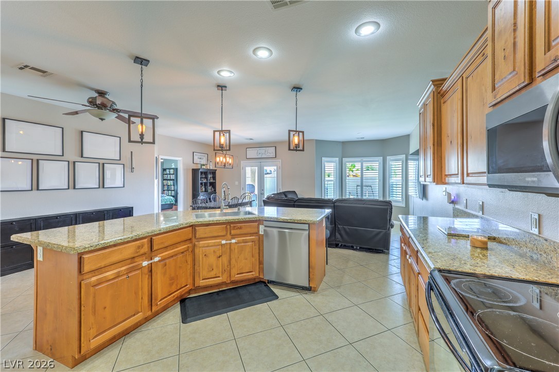 580 Lillian Condie Road Overton, NV 89040 - Photo 6 of 37 A generously sized kitchen island anchors this open-concept living space, featuring abundant cabinetry and gleaming countertops.