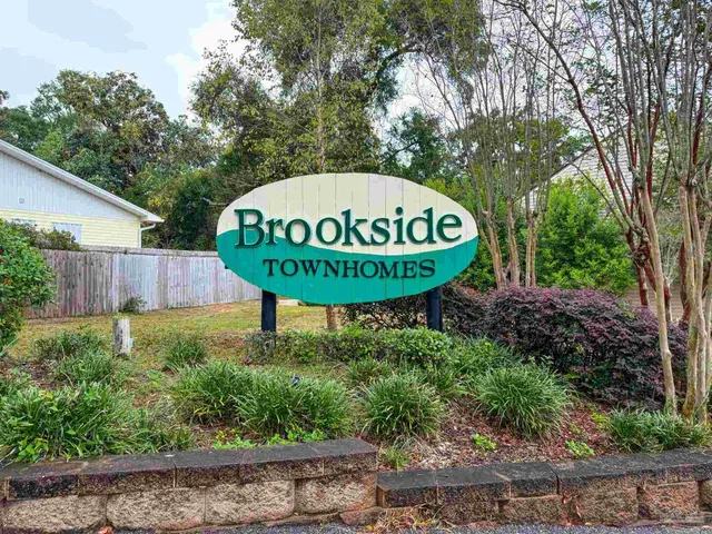 a blue sign sitting in front of a tree