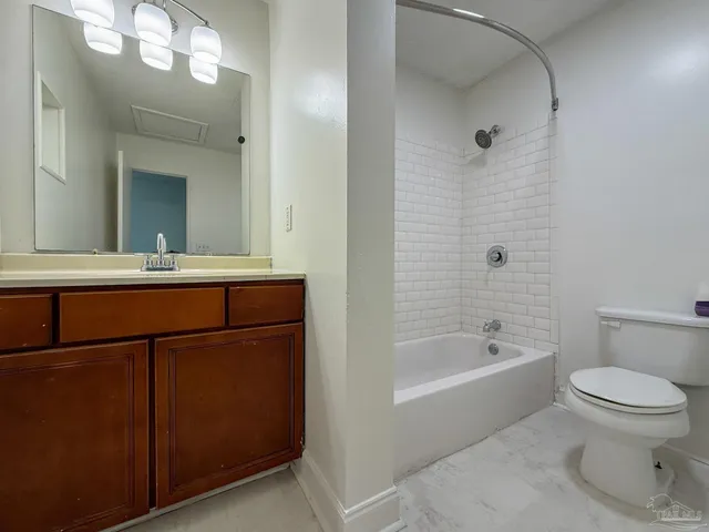 a bathroom with a bathtub shower sink vanity and toilet