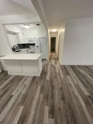 a view of kitchen with cabinets and wooden floor