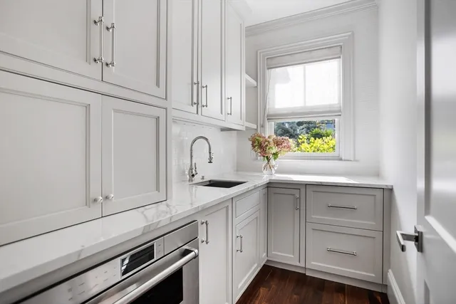 a kitchen with white cabinets and a window