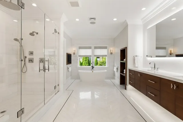 a bathroom with a tub sink shower and mirror