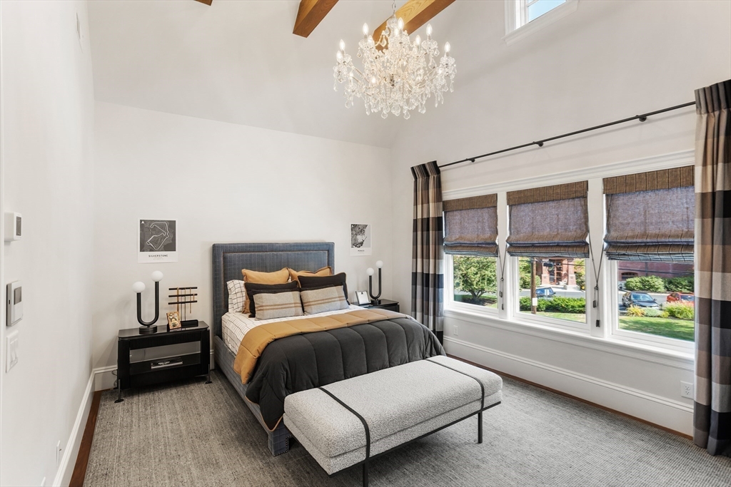 32 Forest Street Lexington, MA 02421 - Photo 18 of 33 a bedroom with a large bed and a chandelier