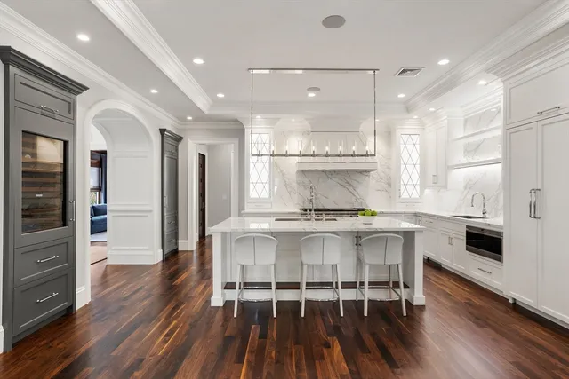 a kitchen with stainless steel appliances a white table chairs and a refrigerator