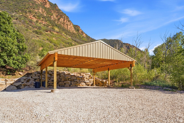 2640 East Weber Canyon Road Oakley, UT 84055 - Photo 46 of 56 Gravel surface, covered structure, wood beam construction, metal roof, stone retaining wall, mountain backdrop