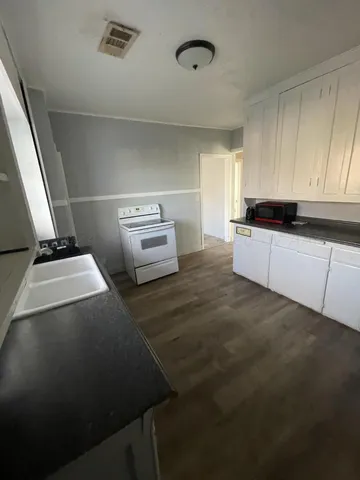 a kitchen with granite countertop a sink and a stove top oven