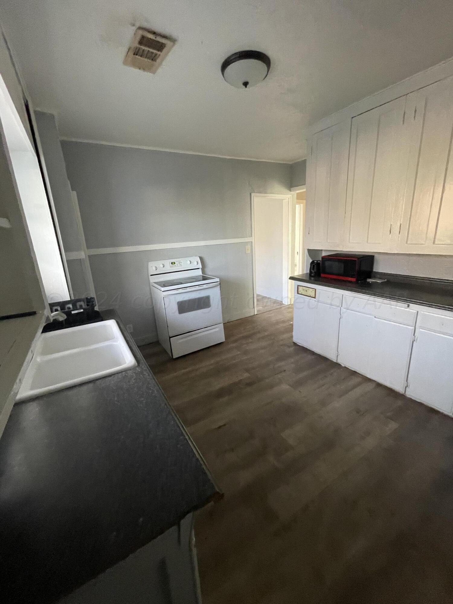 1102 South Western Street Amarillo, TX 79106 - Photo 6 of 9 a kitchen with granite countertop a sink and a stove top oven