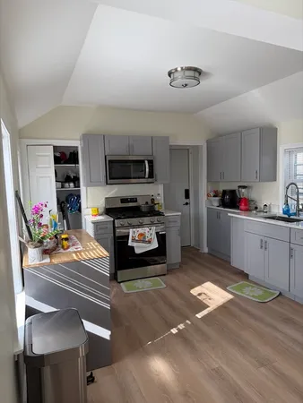 a kitchen with stainless steel appliances kitchen island granite countertop a stove and cabinets