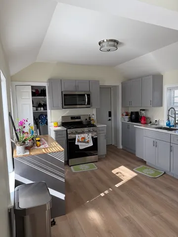 a kitchen with stainless steel appliances kitchen island granite countertop a stove and cabinets