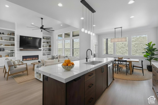 710 East Mountain Road Ogden, UT 84414 - Photo 5 of 10 Open-concept living space featuring a central kitchen island with a sink, stainless steel appliances, and sleek pendant lighting