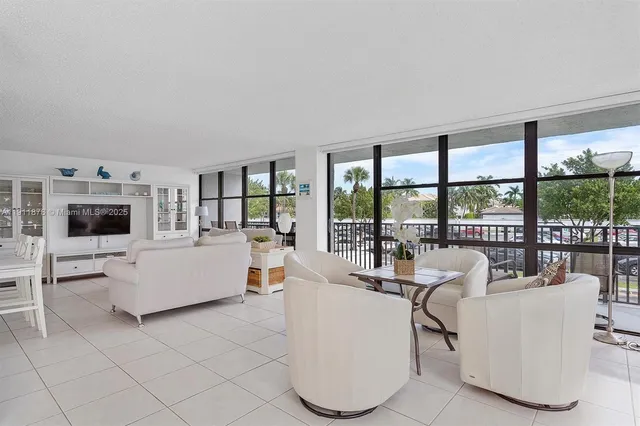 a living room with furniture and floor to ceiling window