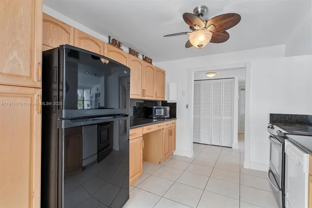 a kitchen with stainless steel appliances granite countertop a refrigerator a stove and a sink