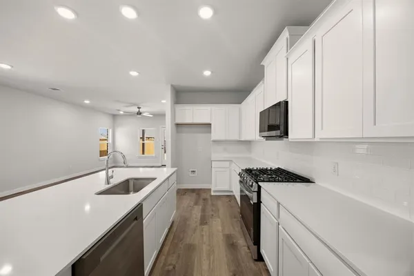 a kitchen with granite countertop a sink and white cabinets