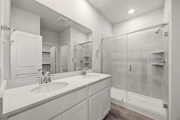 a bathroom with double sink and a mirror