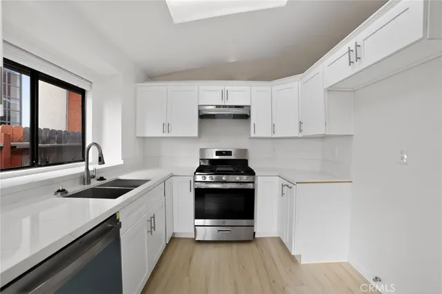 a kitchen with stainless steel appliances a stove sink and cabinets