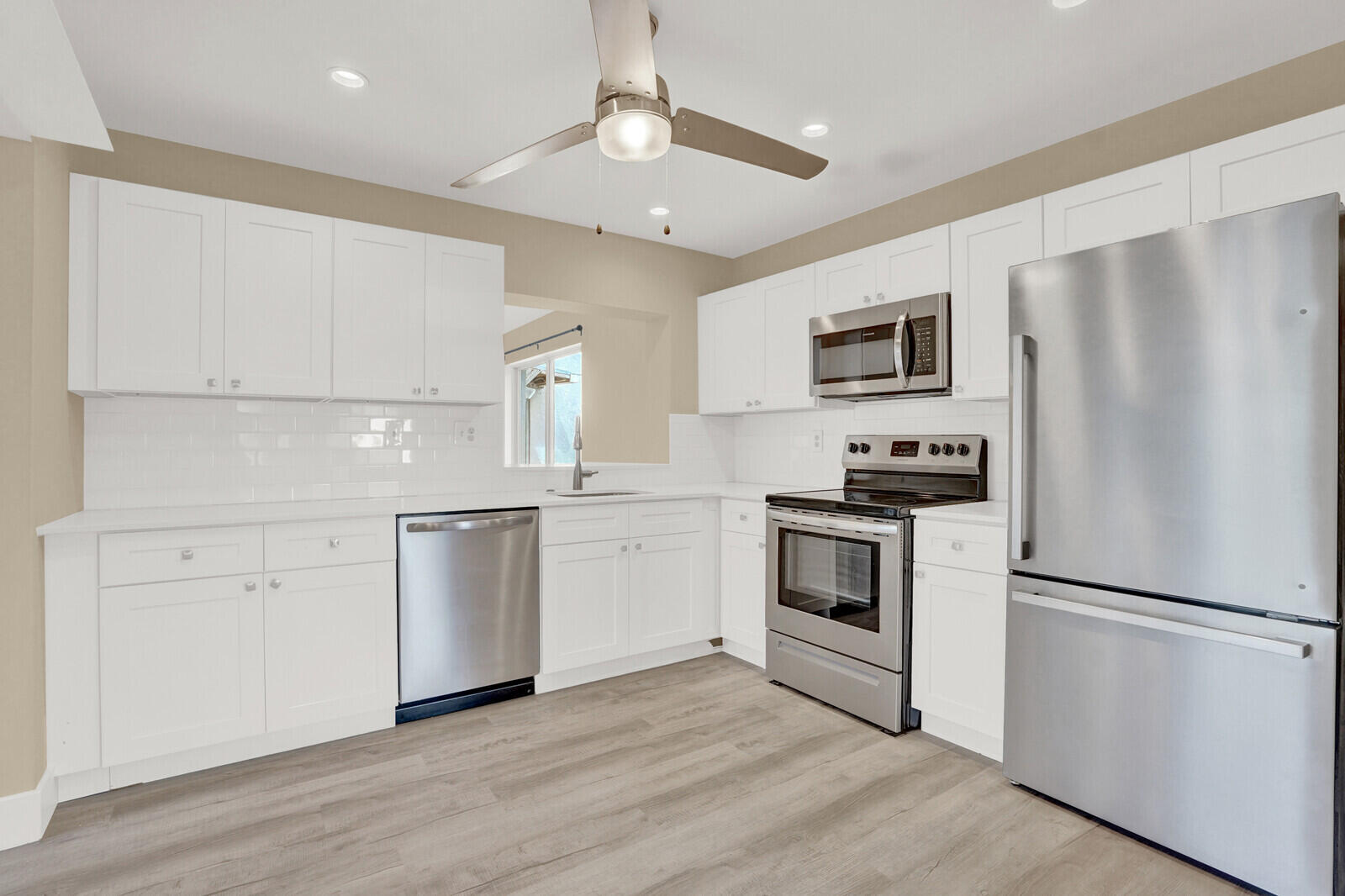 101 Northwest 9th Street Boca Raton, FL 33432 - Photo 11 of 35 a kitchen with white cabinets and stainless steel appliances