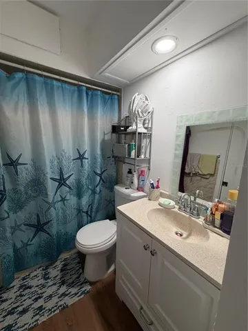 a bathroom with a sink toilet vanity and shower