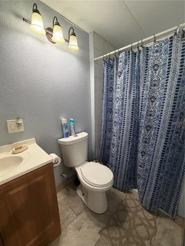 a bathroom with a toilet and shower curtain