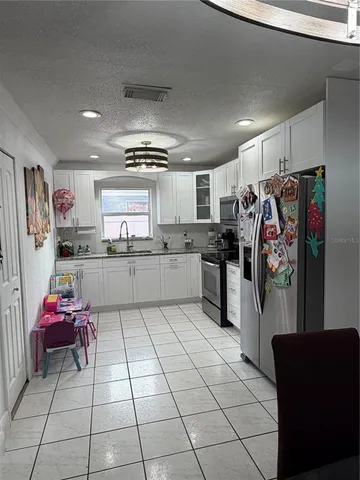 a kitchen with granite countertop a refrigerator and a sink