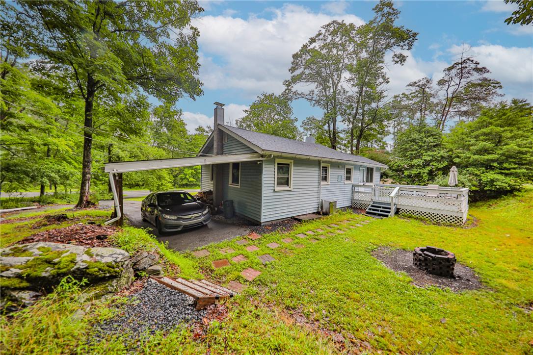 5599 Minks Pond Road Bushkill, PA 18324 - Photo 49 of 64 A tranquil woodside home featuring a spacious deck for outdoor living.