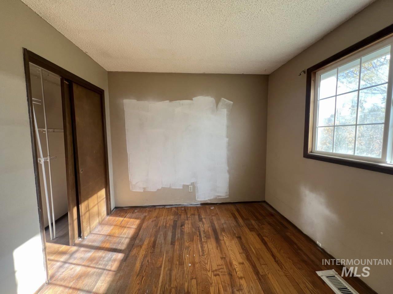 905 West Adams Street Garfield, WA 99130 - Photo 11 of 19 Unfurnished bedroom with hardwood / wood-style floors, a textured ceiling, and a closet