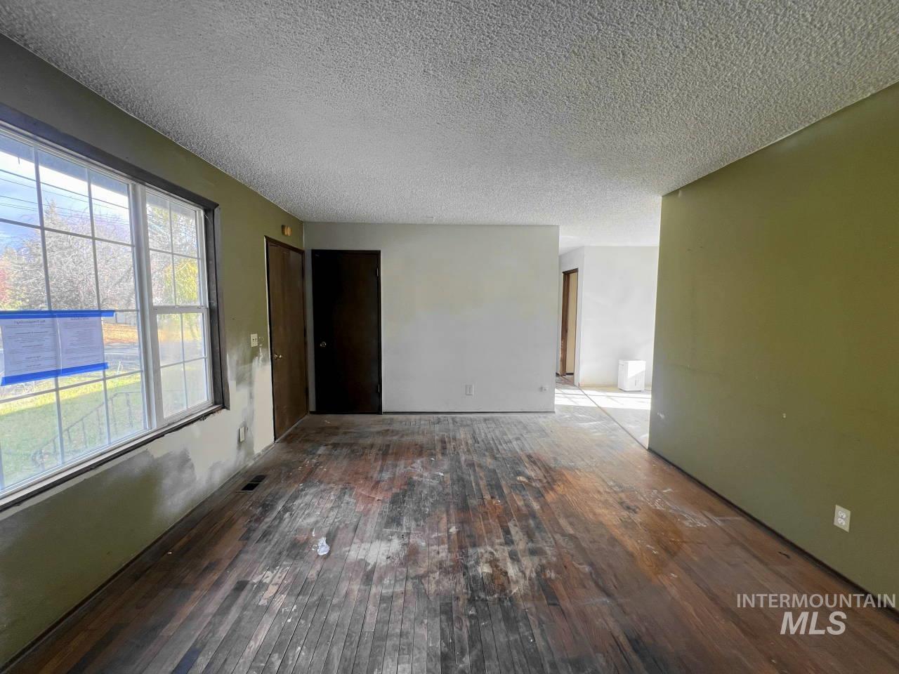 905 West Adams Street Garfield, WA 99130 - Photo 3 of 19 Unfurnished room featuring a textured ceiling and hardwood / wood-style floors