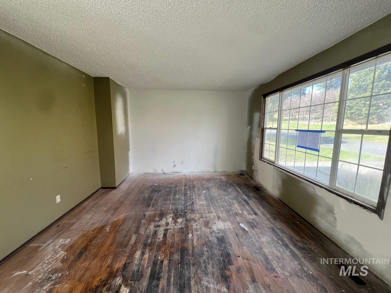 905 West Adams Street Garfield, WA 99130 - Photo 4 of 19 Spare room with dark wood-style floors and a textured ceiling