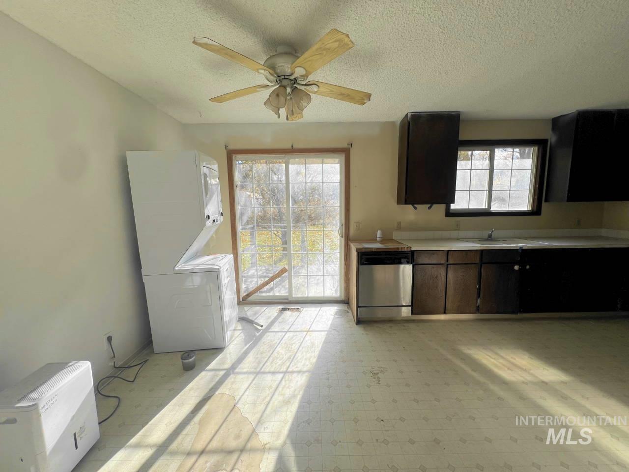 905 West Adams Street Garfield, WA 99130 - Photo 5 of 19 Kitchen with light countertops, stainless steel dishwasher, a textured ceiling, light flooring, and a ceiling fan