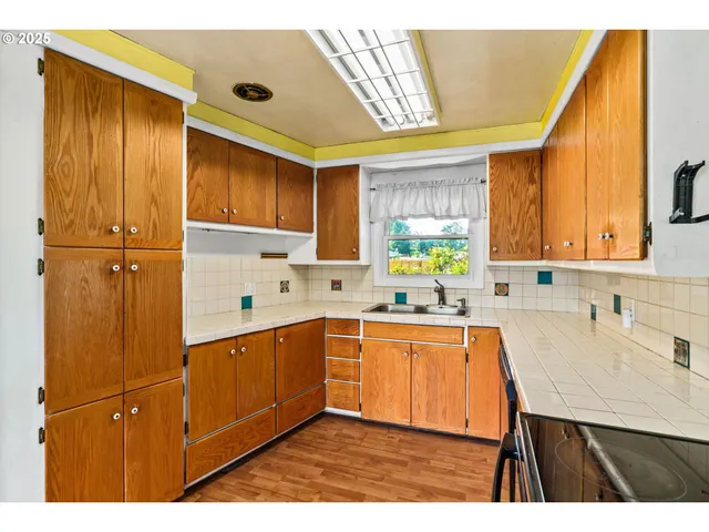 a kitchen with a sink a window and cabinets