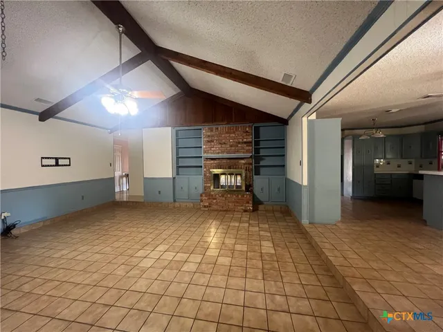 a view of a hallway with wooden floor and a kitchen