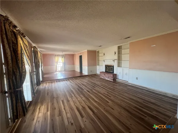 a view of a room with wooden floor and electronic appliances